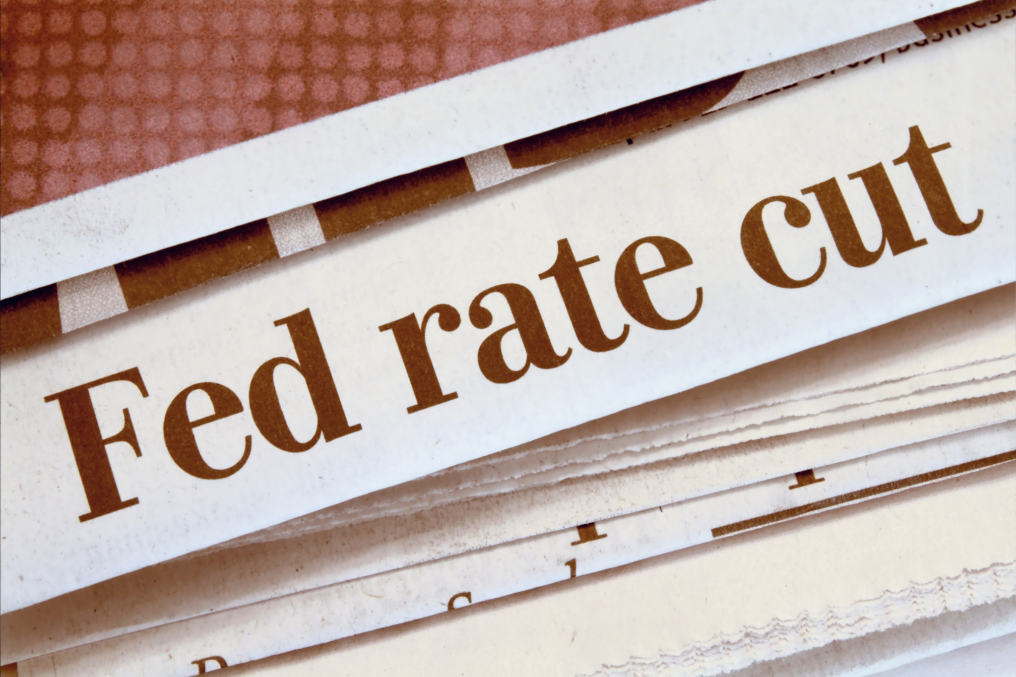 Fed rate cut headline in a newspaper, indicating potential changes in interest rates affecting financial markets.